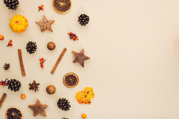 Pattern made of pine cone, leaves, anis, wheat, dried orange and cinnamon stick. Minimal flat lay concept on beige background. Seasonal mood for autumn in october.