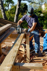 Carpenter using a power saw to cut lumber