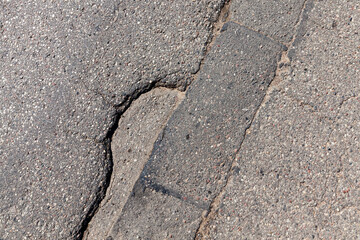 an asphalt road with a lot of holes and damage