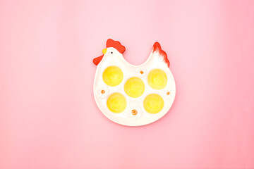 A plate for Easter eggs in the shape of a chicken, Easter celebration concept, pink background with place for text