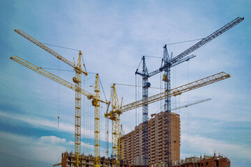 construction cranes are erecting a multi-storey building.