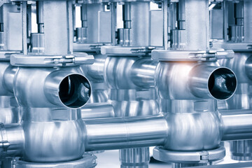 Pipelines from stainless steel, a system for pumping liquids or milk for the food industry. Abstract industrial background.