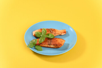 Fried red salmon with basil leaves.