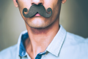 close up of a man's chin wearing a fake paper made mustache - Movember  - obrazy, fototapety, plakaty