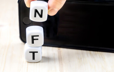 NFT or Non-Fungible token letters and dices, nft‘s are a blockchain market for art and collections smart phone with copy space