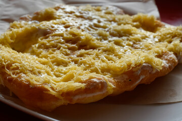 Hungarian street food - langos. Flatbread with sour cream-garlic sauce and cheese - obrazy, fototapety, plakaty