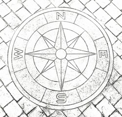 A black and white shot of a compass sign