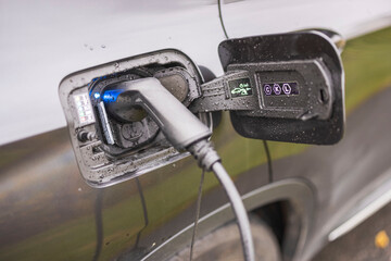 Close up view of electric vehicle with charging cable. Sweden.