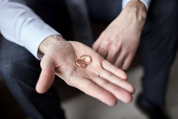 man holding wedding rings, groom getting ready in the morning before ceremony
