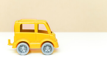 Yellow little toy car on white background as a gift for kids, boy. baby's stuff with copy space