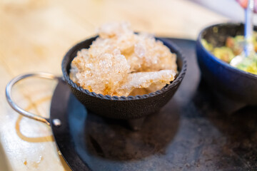 Bowls of pork rinds and guacamole on Mexican comal