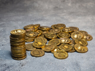 Pyramid of coins on a gray background. A pile of coins.