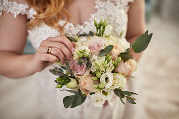 bouquet in hands of the bride, woman getting ready before wedding ceremony