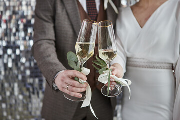 Couple toasting wine glasses for celebration. Two people holding flutes doing cheers