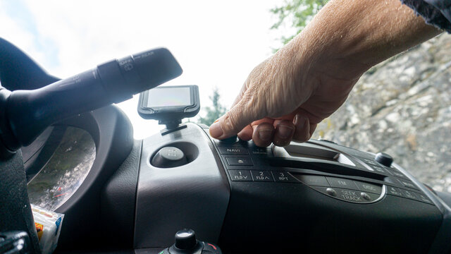 hand manipulating the controls in the frame of a car