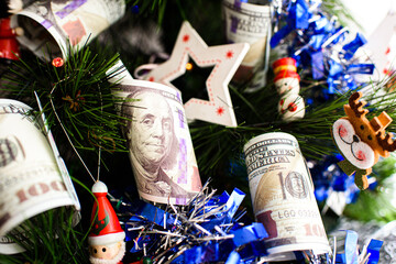 Dollar bills hanging on a Christmas tree alongside traditional Christmas decorations.