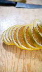 Sliced orange slices and knife on wooden cutting board