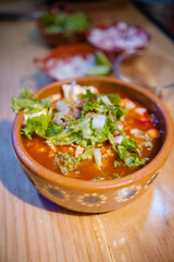 Clay bowl of condiments and delicious traditional Mexican pozole