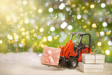 Tractor transports boxes with gifts on the background of the Christmas tree and the side of the...