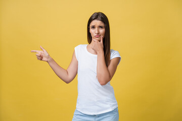 Closeup portrait of young pretty unhappy, serious woman pointing at someone as if to say you did something wrong, bad mistake isolated on yellow background. Negative emotion, facial expression feeling - obrazy, fototapety, plakaty
