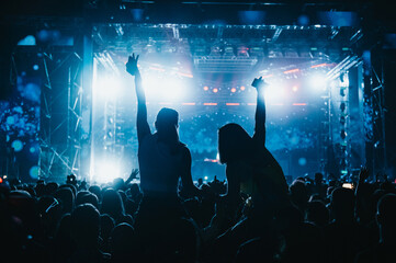 Two girls in a audience crowd having fun and enjoying concert on a festival