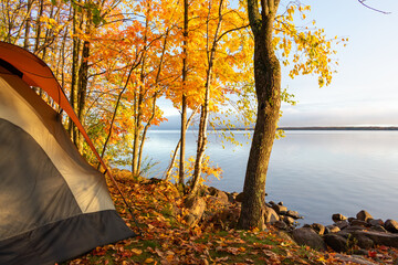 Waterside campsite in autumn with beautiful fall colors - obrazy, fototapety, plakaty
