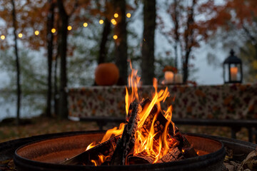 Glowing camp fire at autumn campsite - obrazy, fototapety, plakaty