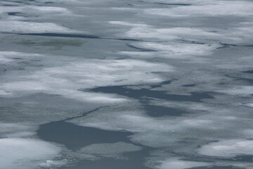 close up of ice melting in the early spring on the frozen lake