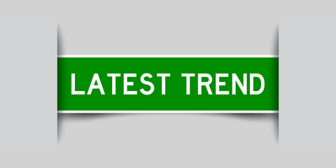 Inserted green color label sticker with word latest trend on gray background