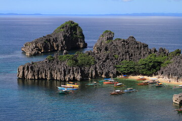 Fototapeta na wymiar aerial view of group of boats in a small cove and beach surrounded by the ocean. Philippines 