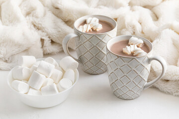 Fototapeta na wymiar Cups of hot cocoa drink and marshmallows on light background