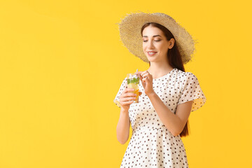 Beautiful young woman with fresh lemonade on color background