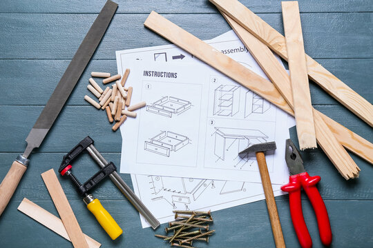 Furniture Assembling Instructions And Tools On Blue Wooden Background