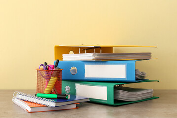 Office folders and stationery on color background