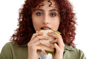 Pretty young woman eating tasty sandwich on white background