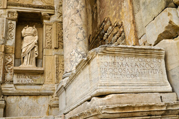 A marble statue of Episteme (Knowledge) stands in a niche of the ruined Roman facade of the Library...