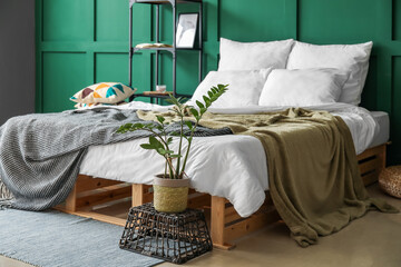 Interior of green bedroom with cozy bed and stylish decor