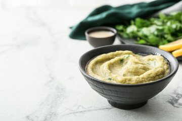Bowl with tasty baba ghanoush on light background, closeup