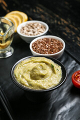 Bowl with tasty baba ghanoush on black table, closeup