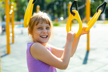 Portrait of a positive nine year old teenage girl walking in the yard on a playground on a warm...