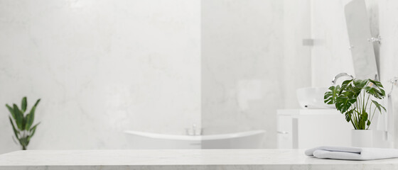 Marble bathroom tabletop for montage with towel and minimal houseplant over modern bathroom