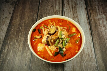 Traditional spicy red curry soup of tofu sheet mixed with chilly and string bean serving in the bowl. Famous vegetarian menu in Asia restaurant.  - obrazy, fototapety, plakaty