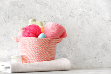 Basket with different bath supplies on light background