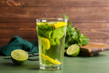 Glass of tasty mint tea with lemon on table