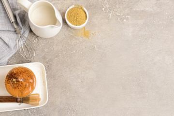 Glass of tasty dalgona hojicha latte, milk and powder on grunge background