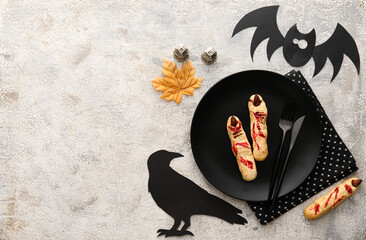 Stylish Halloween table setting with cookies and decor on grey background