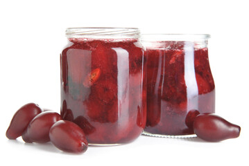 Jars of tasty dogwood jam and berries on white background