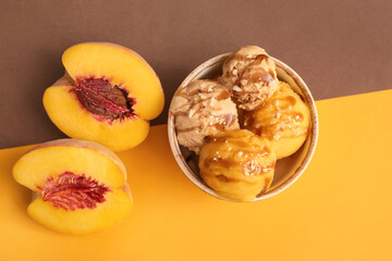Bowl of delicious ice cream balls with peach on color background