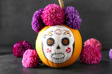 Pumpkin with painted skull on dark background. Celebration of Mexico's Day of the Dead (El Dia de Muertos)