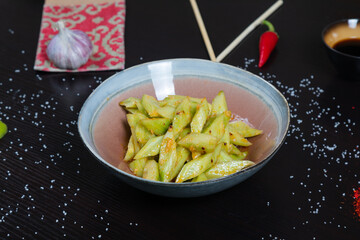Salad with chopped cucumbers in garlic sauce on a black background
